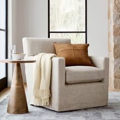 a living room with a chair, table and window