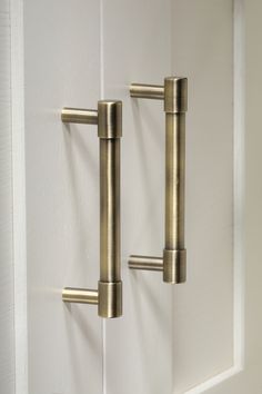 two brass handles on a white door