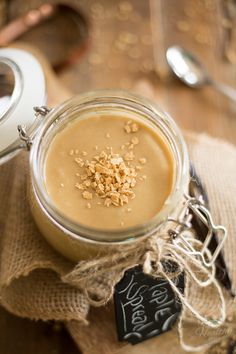 a glass jar filled with food sitting on top of a table next to a spoon