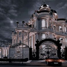 a car is parked in front of a large building with an ornate gate and entrance