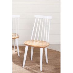 two white wooden chairs sitting on top of a carpeted floor next to each other