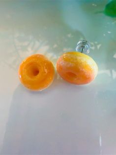 two glazed doughnuts sitting on top of a white table next to each other