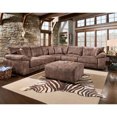 a living room with a sectional couch and zebra rug