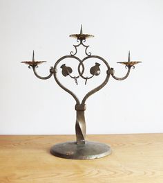 a metal candelabra sitting on top of a wooden table