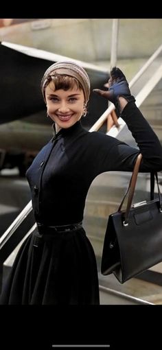 a woman standing on an escalator with her arms outstretched