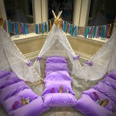 purple pillows are arranged on the floor in front of a teepee tent