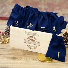 the wooden box is filled with gold coins and blue drawstrings, along with pine cones