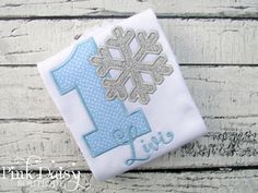 a snowflake birthday shirt with the number one on it