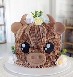 a cake made to look like a cow with flowers on it's head and ears