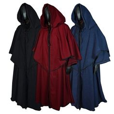 three different colored hooded cloaks on mannequins, one in black and one in red