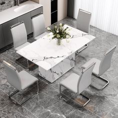 a marble dining table surrounded by white chairs