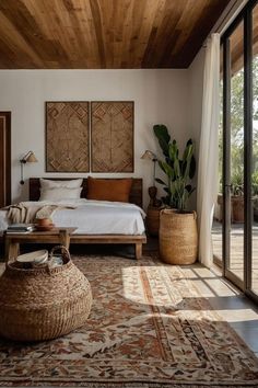 a bedroom with a large bed sitting next to a wooden table and two planters on either side of the bed