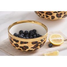 blueberries and lemons are in a leopard print bowl