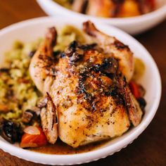 two white bowls filled with food on top of a wooden table