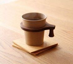 a small cup sitting on top of a wooden coaster