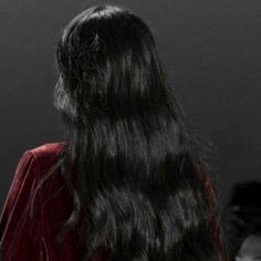 the back of a woman's head with long black hair and red jacket on