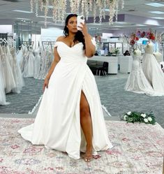 a woman taking a selfie in front of her wedding dress