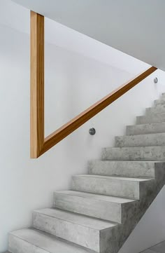 the stairs are made of concrete and have wooden handrails