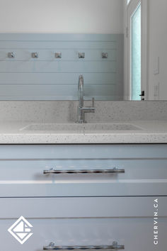 a bathroom sink sitting under a mirror next to a counter top with two faucets