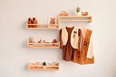 three wooden shelves with shoes and other items hanging on the wall next to each other