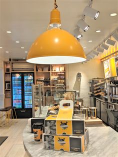 the inside of a restaurant with many items on display and lights hanging from the ceiling