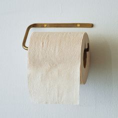 a roll of toilet paper hanging on a wall with a metal holder attached to it