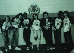 a group of young men standing next to each other in front of a wall with an eagle on it