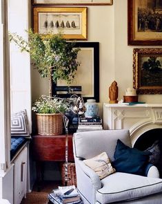 a living room filled with furniture and pictures on the wall above it's fireplace