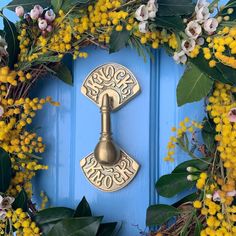 a blue door with yellow flowers and a metal lock on it's front handle