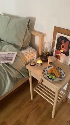 a small table with food on it next to a bed