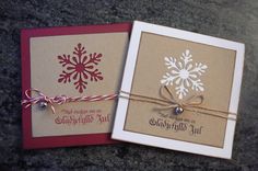 two christmas cards tied with twine on top of a granite surface, one has a snowflake design