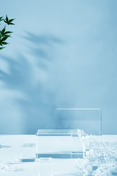 a vase filled with flowers on top of a white table next to a blue wall