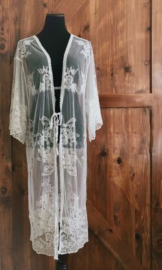 "An overlayering piece made with soft embroidered sheer lace. Makes for a super sweet cover up for any outfit! ONE SIZE FITS MOST - SMALL, MEDIUM, LARGE, XL Length: 46\" Bust: 24\" flat measure (tie front, one size fits all) Armhole: 14\" Get two items or more and your shipping is on us! Enter code FREESHIP at checkout! (US shipping only)" Bohemian Lace Beach Cover-up, Spring Festival Lace Cover-up, White Wrap Cover-up For Spring, Sheer Lace Beachwear Cover-up, Bohemian Fitted Sheer Cover-up, Festival Open Front Cover-up, Bohemian Lace Patchwork For Spring, Fitted Bohemian Cover-up With Lace Trim, Bohemian Fitted Lace For Spring