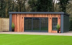 a garden room with sliding glass doors on the side and green grass in the front yard