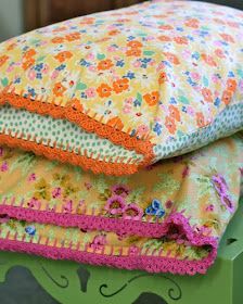 three pillows stacked on top of each other in front of a green bed with floral designs