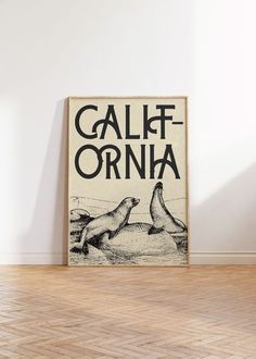 a poster with the words california on it in front of a white wall and wooden floor