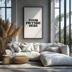 a living room with a large white couch next to tall windows and a potted plant