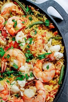 shrimp, rice and vegetables in a skillet with garnishes on top