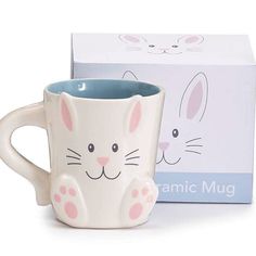 a ceramic coffee mug with a bunny face on it and a box for the mug