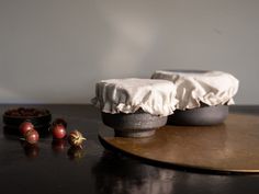 there are some fruit on the table and one is covered with a white cloth next to it