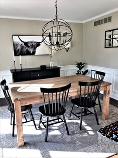 a dining room table with four chairs and a chandelier hanging from the ceiling