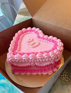 a pink heart shaped cake in a box