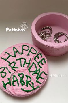 two pink birthday cakes with green writing on them