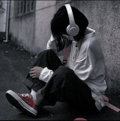 a person sitting on the ground wearing headphones