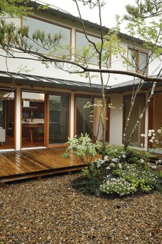 a wooden deck in front of a house with sliding glass doors on the outside and inside