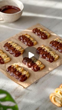 chocolate covered pretzels sitting on top of a table next to some dipping sauce