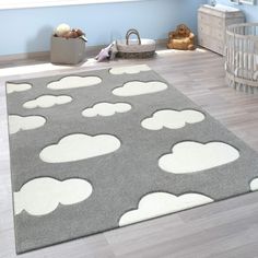 a gray and white rug with clouds on it in a child's nursery room