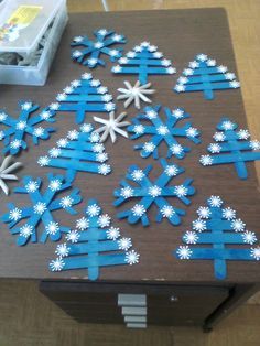 paper snowflakes are arranged on top of a brown table with blue and white strips