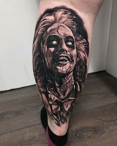 a person with tattoos on their legs has a creepy face and head in the background