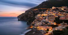 a city on the side of a mountain at night with lights lit up all over it